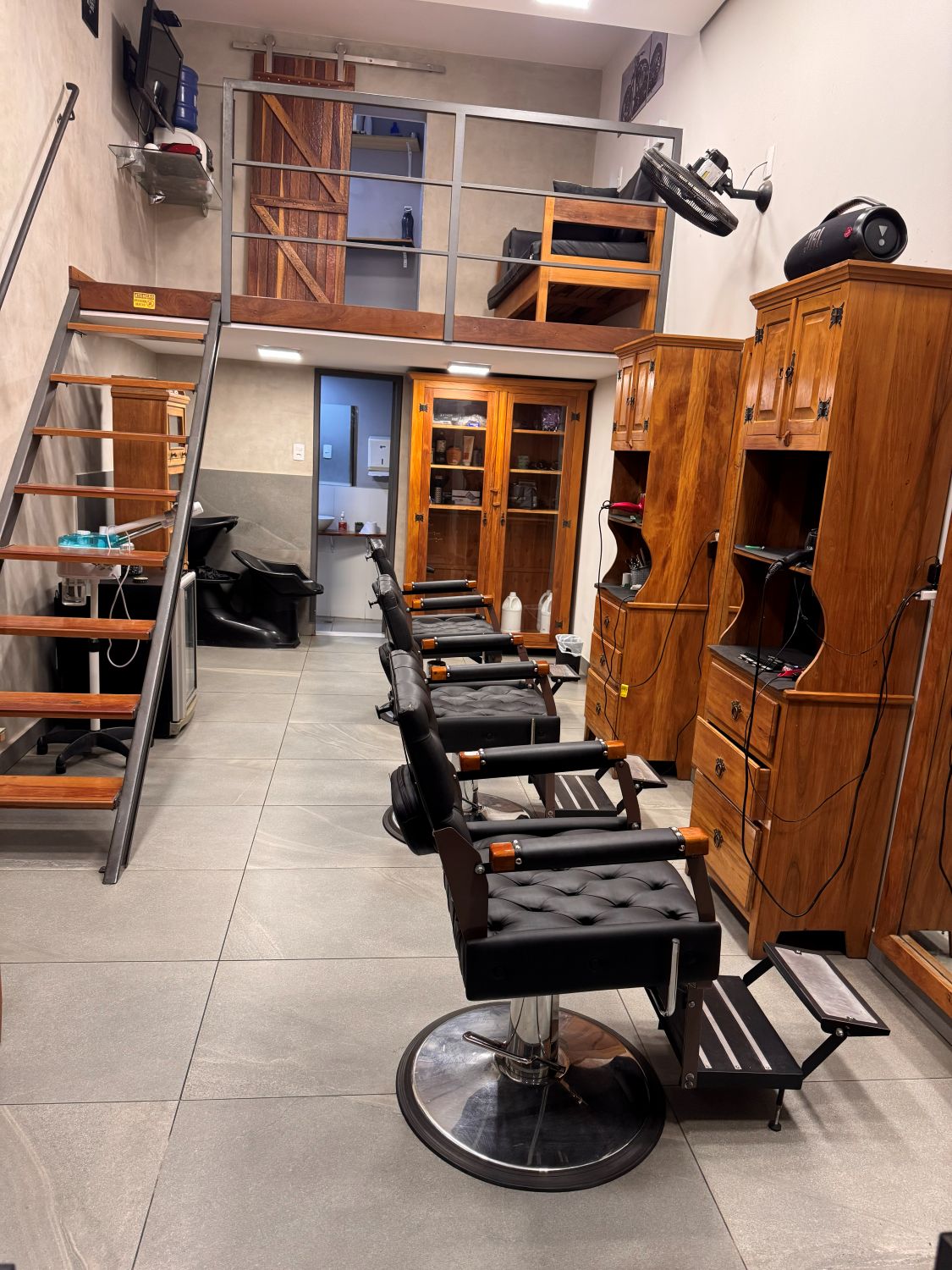 Salão da Barbearia 08 em Nova Lima, com cadeiras de barbeiro enfileiradas, mezanino e marcenaria em madeira
