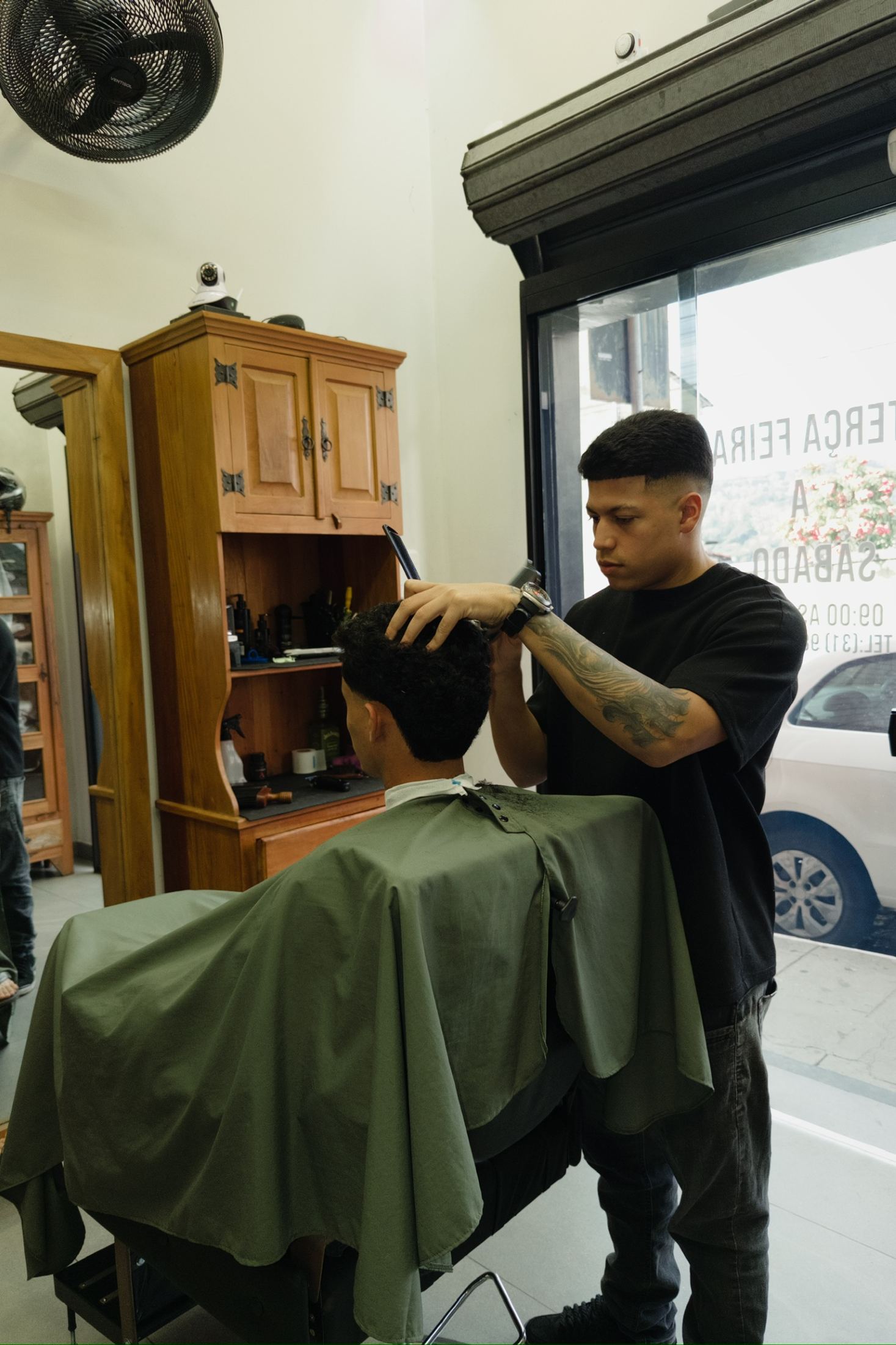 Barbeiro da Barbearia 08 finalizando um corte masculino em Nova Lima