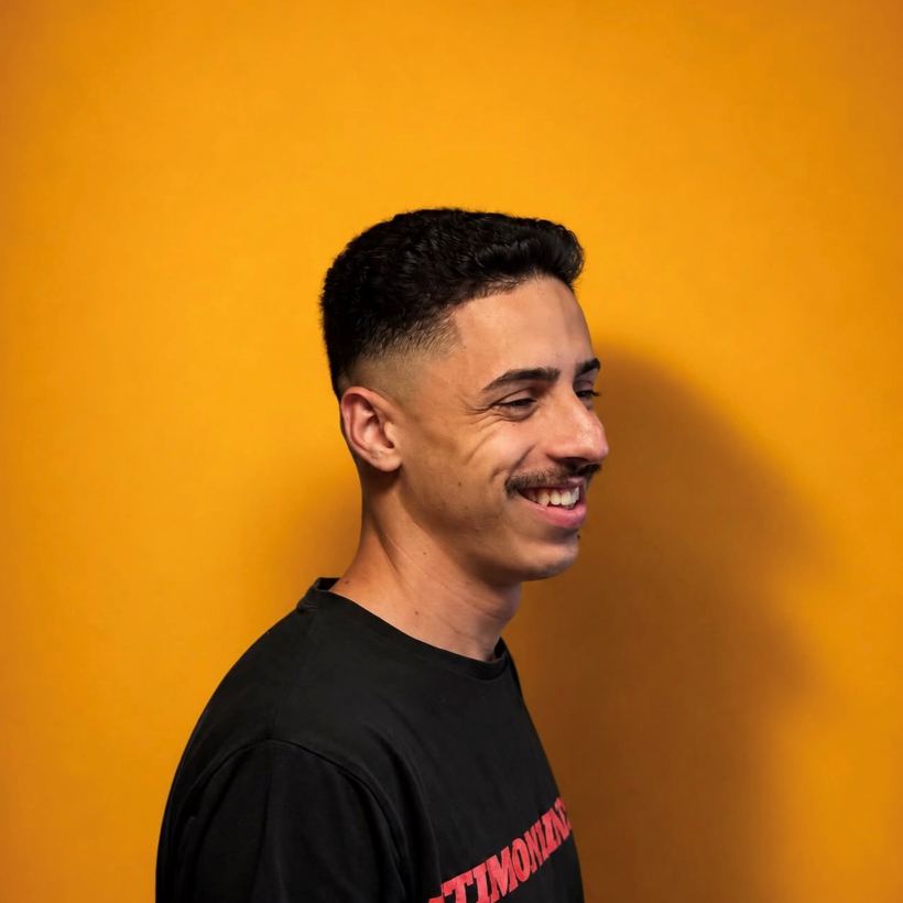 Cliente sorrindo com degradê feito na Barbearia 08