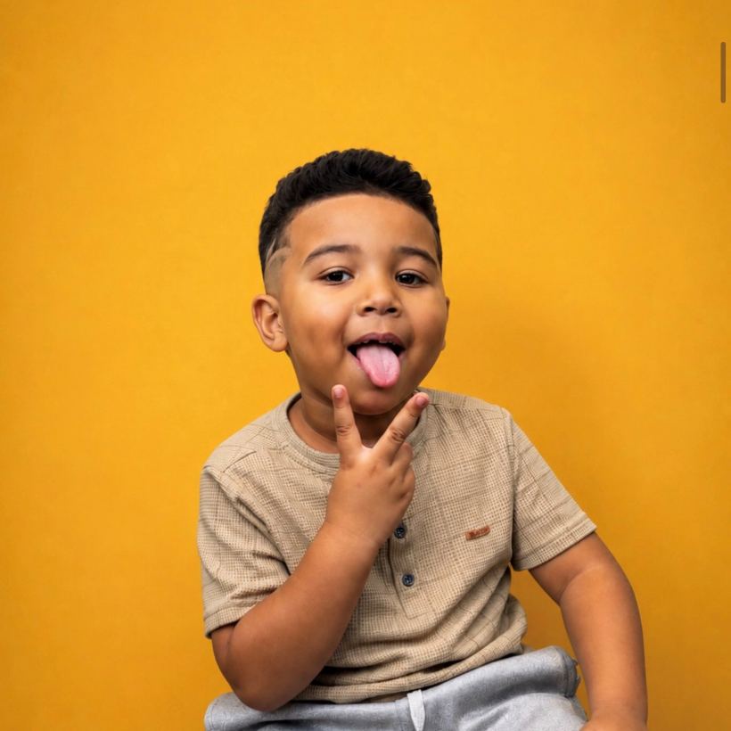 Criança sorrindo com corte infantil feito na Barbearia 08